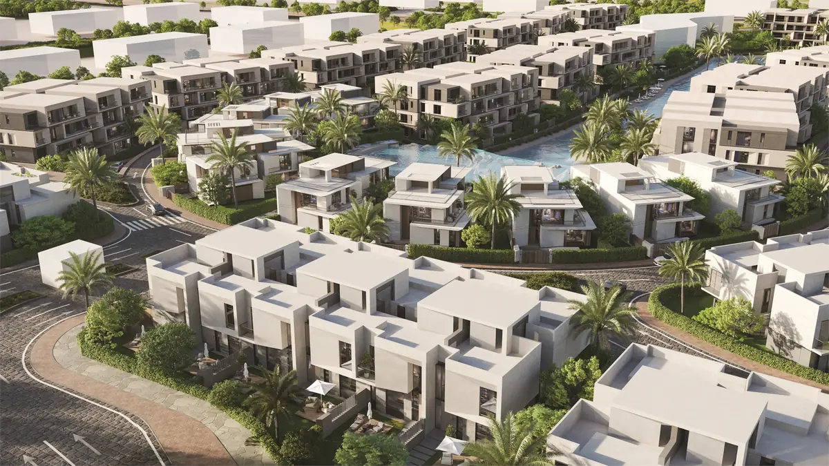 31 West – منظر جوي لمجموعات منازل متلاصقة بيضاء ونخيل حول بحيرة متعرجة
