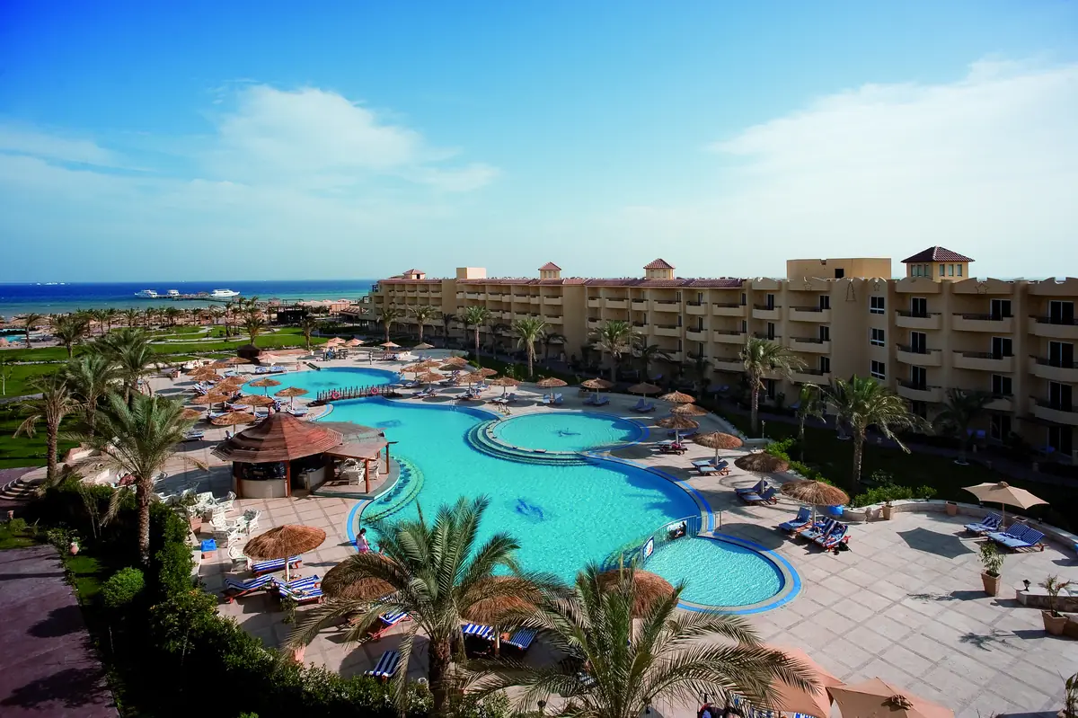 Amwaj Soma Hotel & Spa – Aerial view of the lagoon pools, parasols and terracotta wings toward the sea