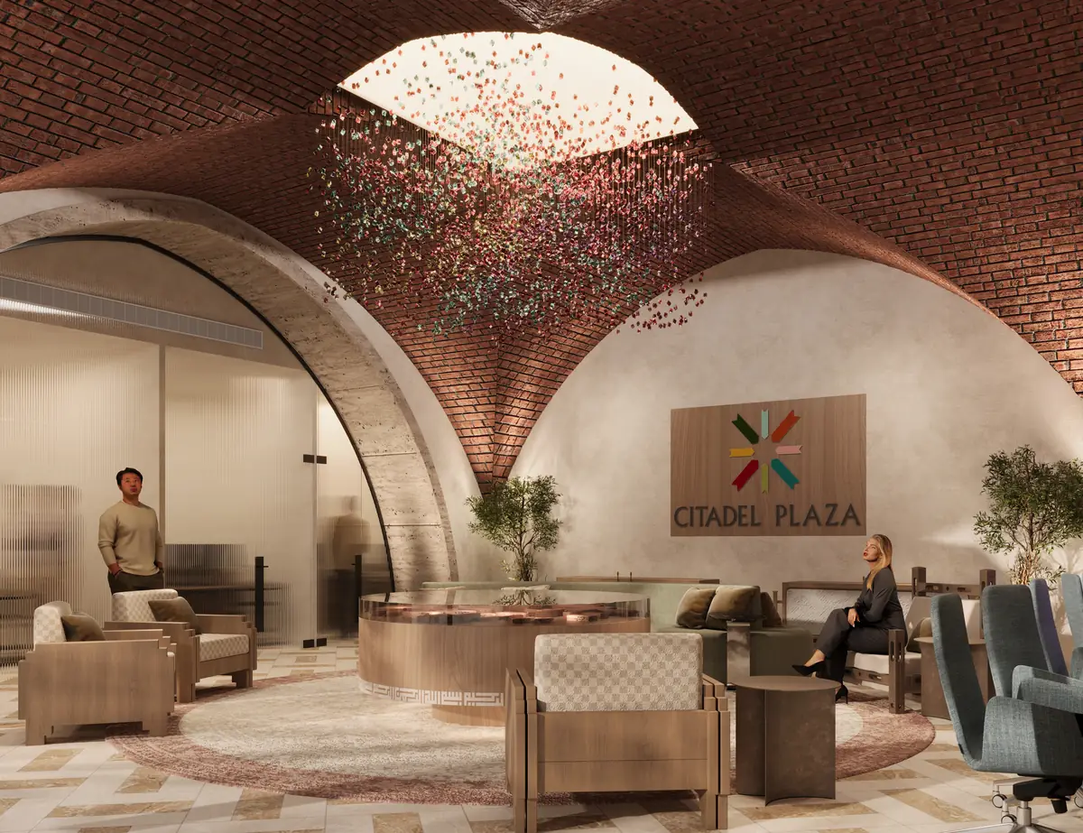Citadel Plaza Sales Office – منظر جانبي عبر قوس من الترافرتين نحو غرفة اجتماعات زجاجية