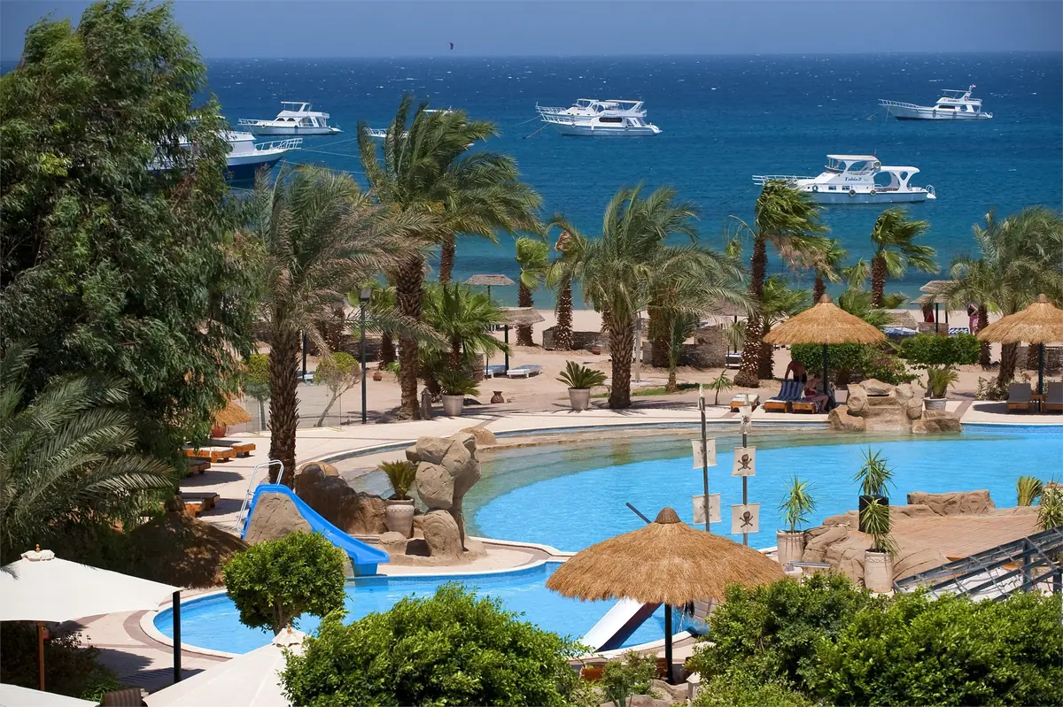 Lotus Bay Resort Renovation – Elevated view over free-form pools and water slides to boats on the Red Sea