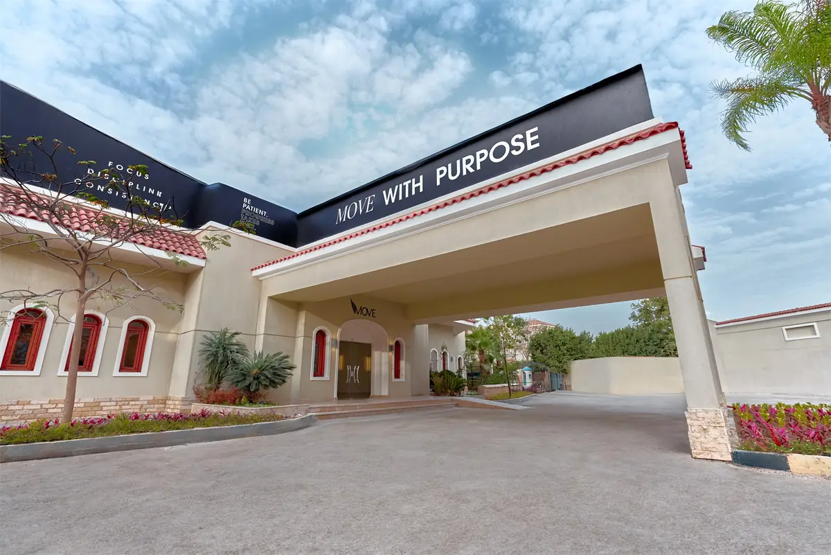 Move – Green Heights Sports Complex – Covered drop-off entrance with slogan signage on a dark fascia