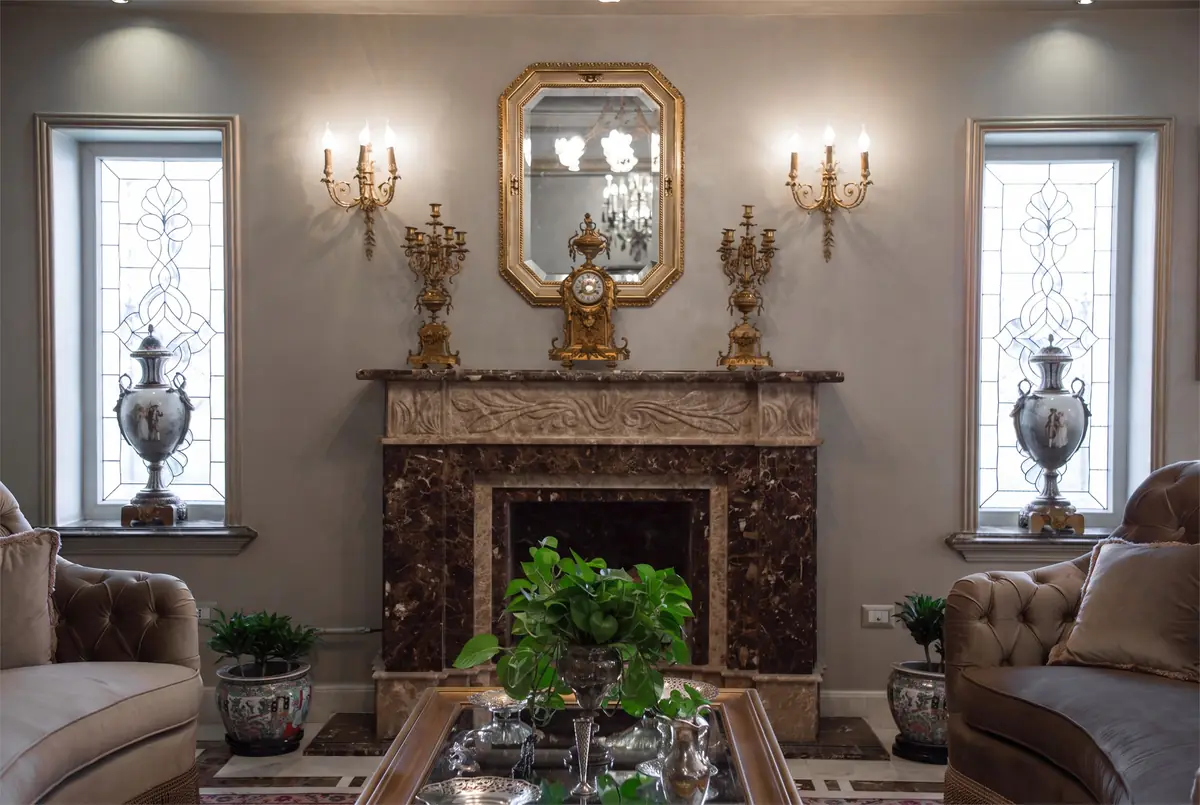 Mrs. M.A.'s Villa – غرفة استقبال بمدفأة رخامية منحوتة بين نوافذ زجاج معشق وشمعدانات جدارية مذهبة