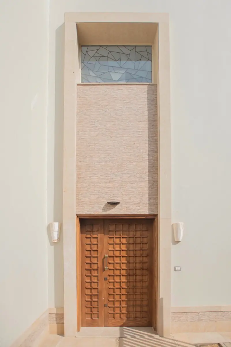 Prof. Dr. H.F.'s Villa – مدخل مرتفع بباب خشبي مزدوج مقسم إلى مربعات وتجويف حجري ونافذة علوية من زجاج منقوش